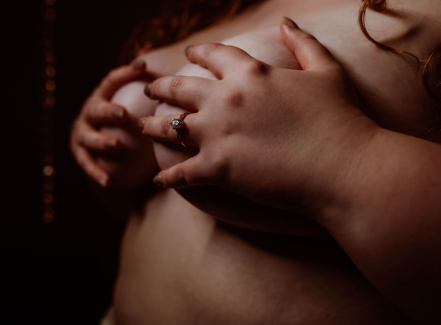 Minneapolis boudoir photography with engagement ring boudoir photos with moody lighting.