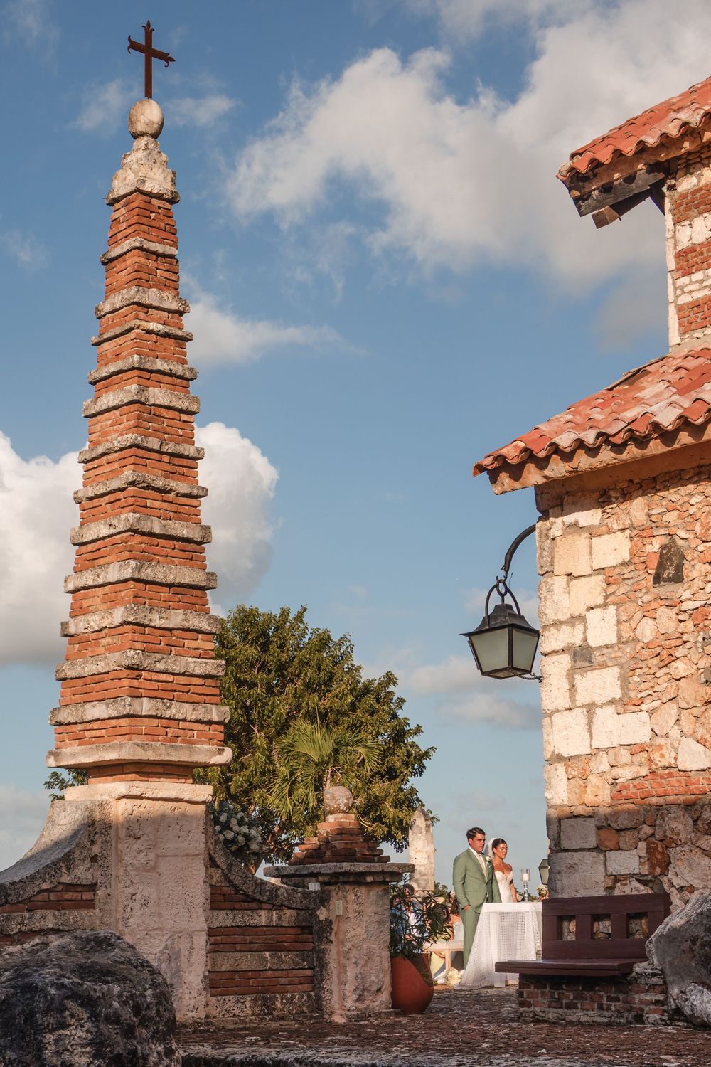 Spanish colonial architecture with stepped brick towers and terracotta roofs against a bright blue sky.