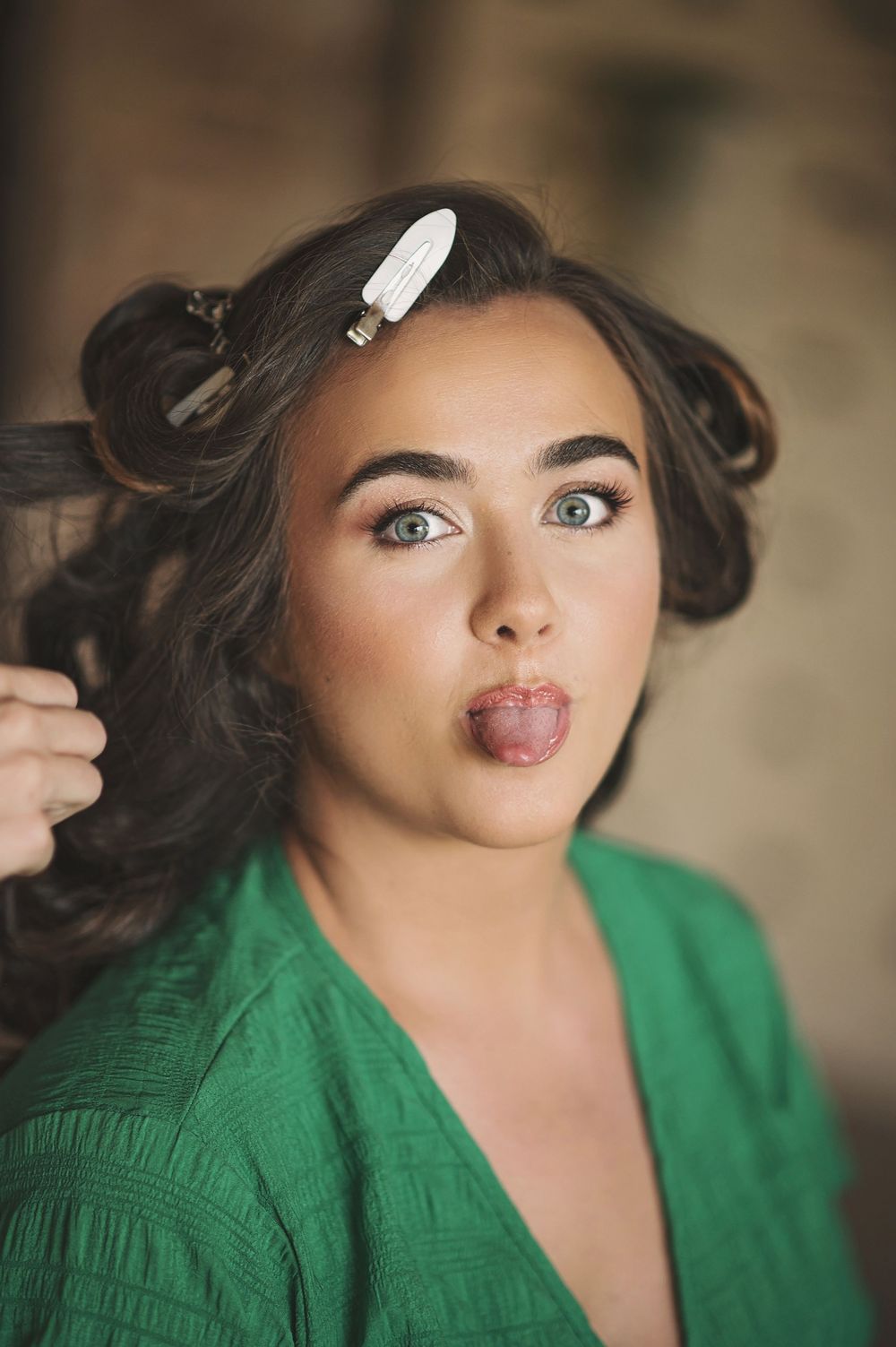Playful behind-the-scenes moment during bridal preparation with hair styling.
