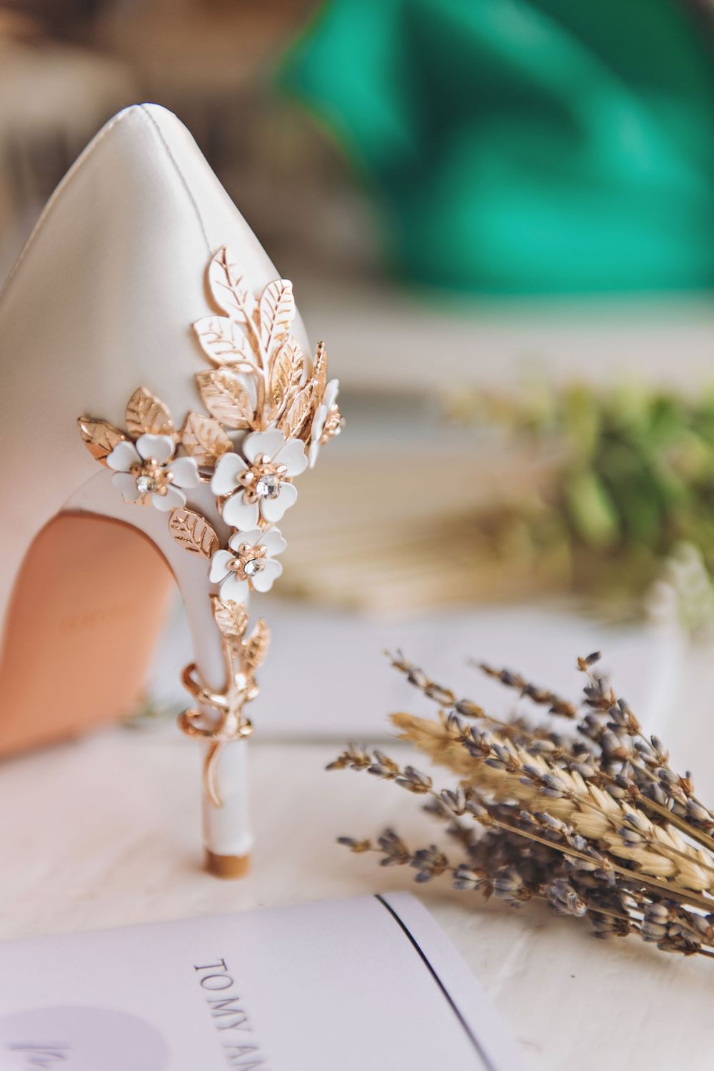 Elegant white bridal heel with ornate gold leaf and floral embellishments on the back.