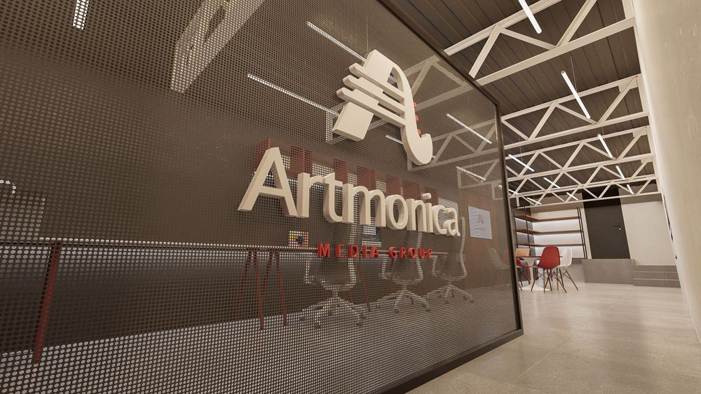 Modern studio interior with Artmonia signage on wall in a minimalist industrial space.