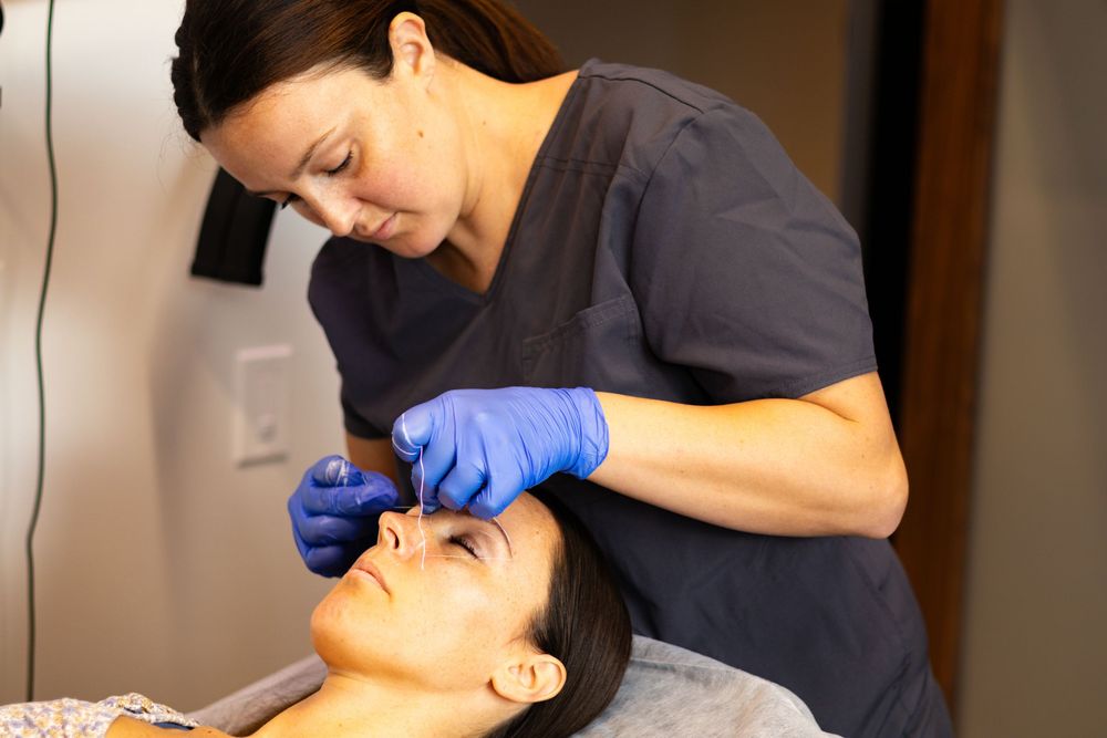 Skincare specialist administering a professional facial treatment in a medical spa environment.