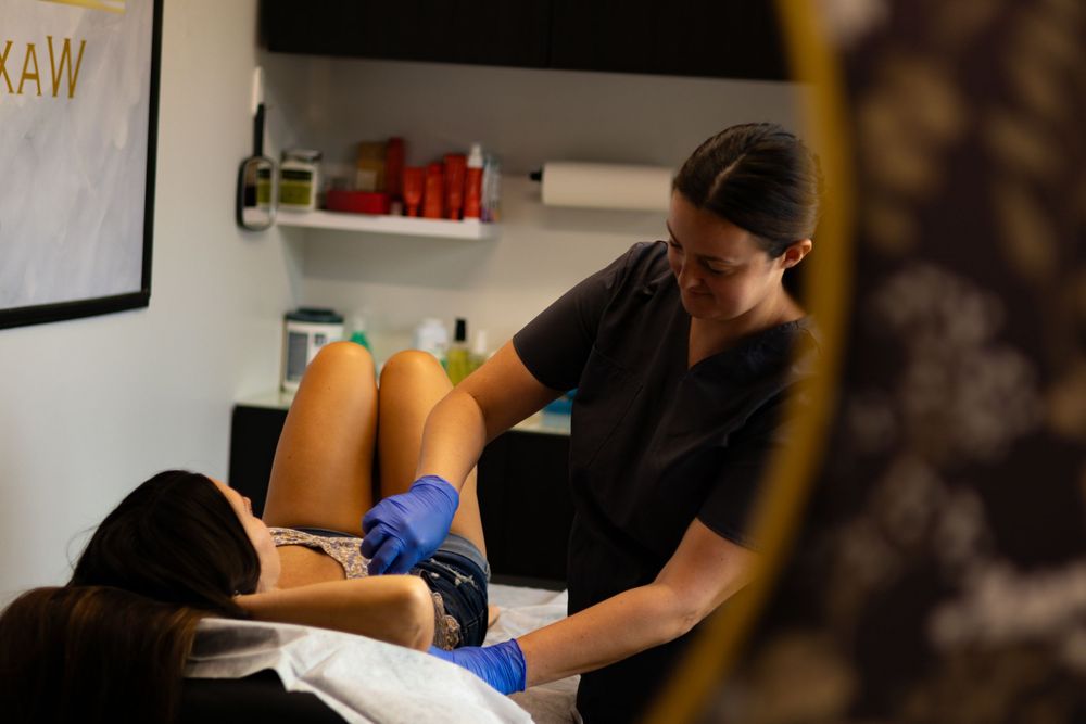 Aesthetician wearing blue gloves performing a facial treatment in a spa setting.