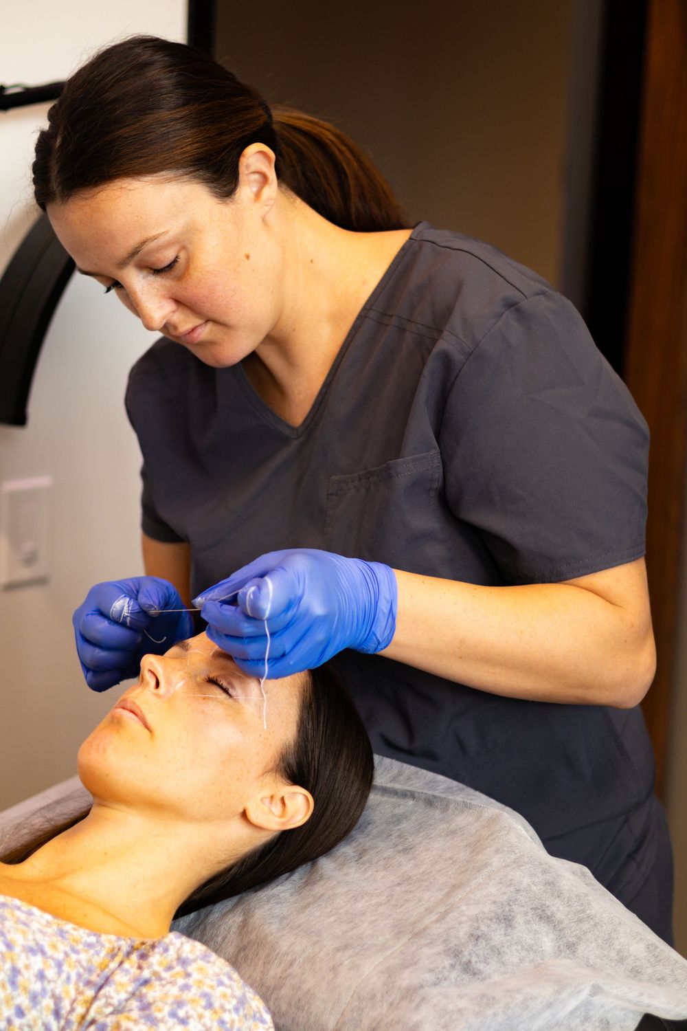 Skincare specialist performing precise facial treatment in professional setting.