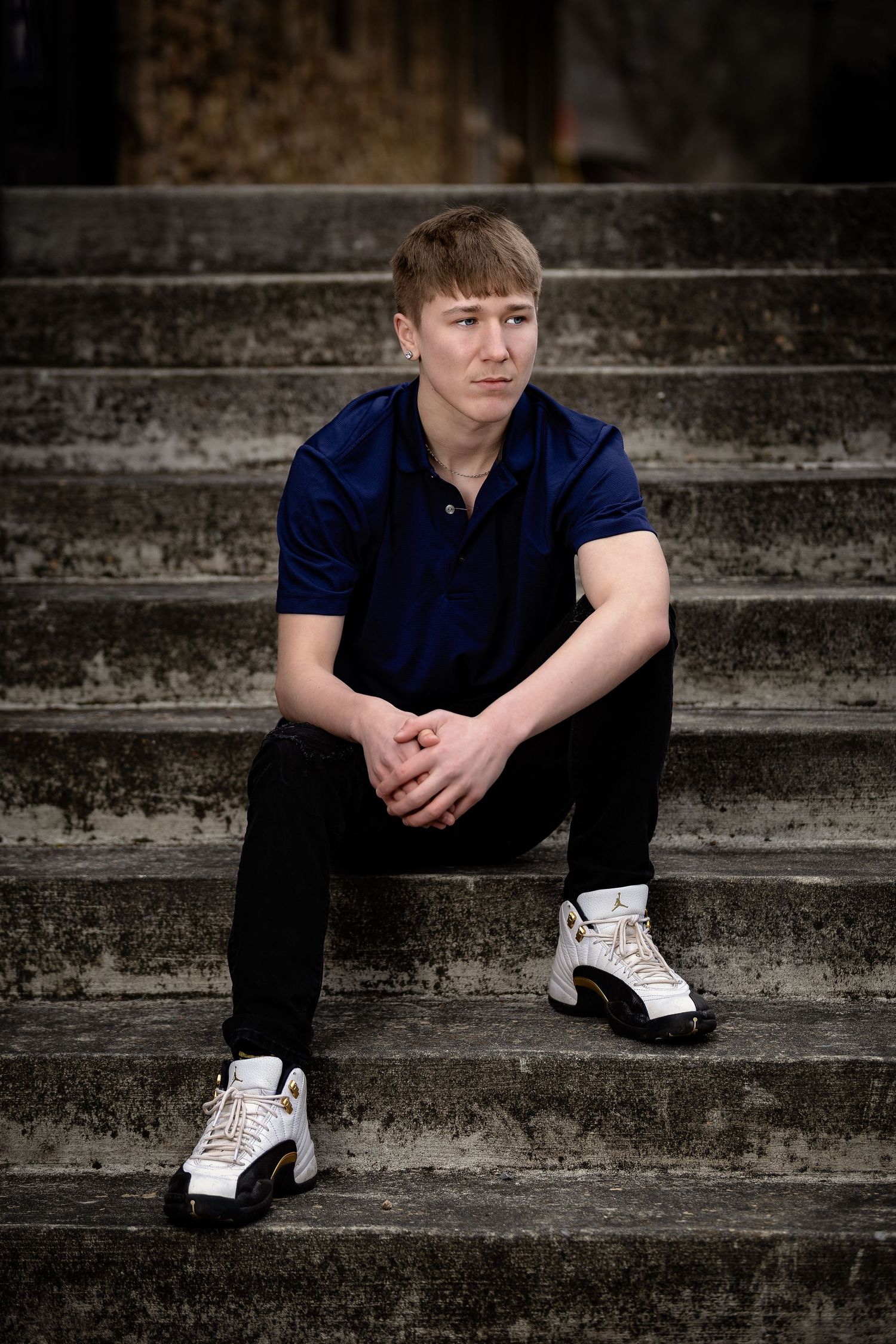 Candid lifestyle senior session in Lincoln, Alabama, with the student sitting on industrial concrete stairs.