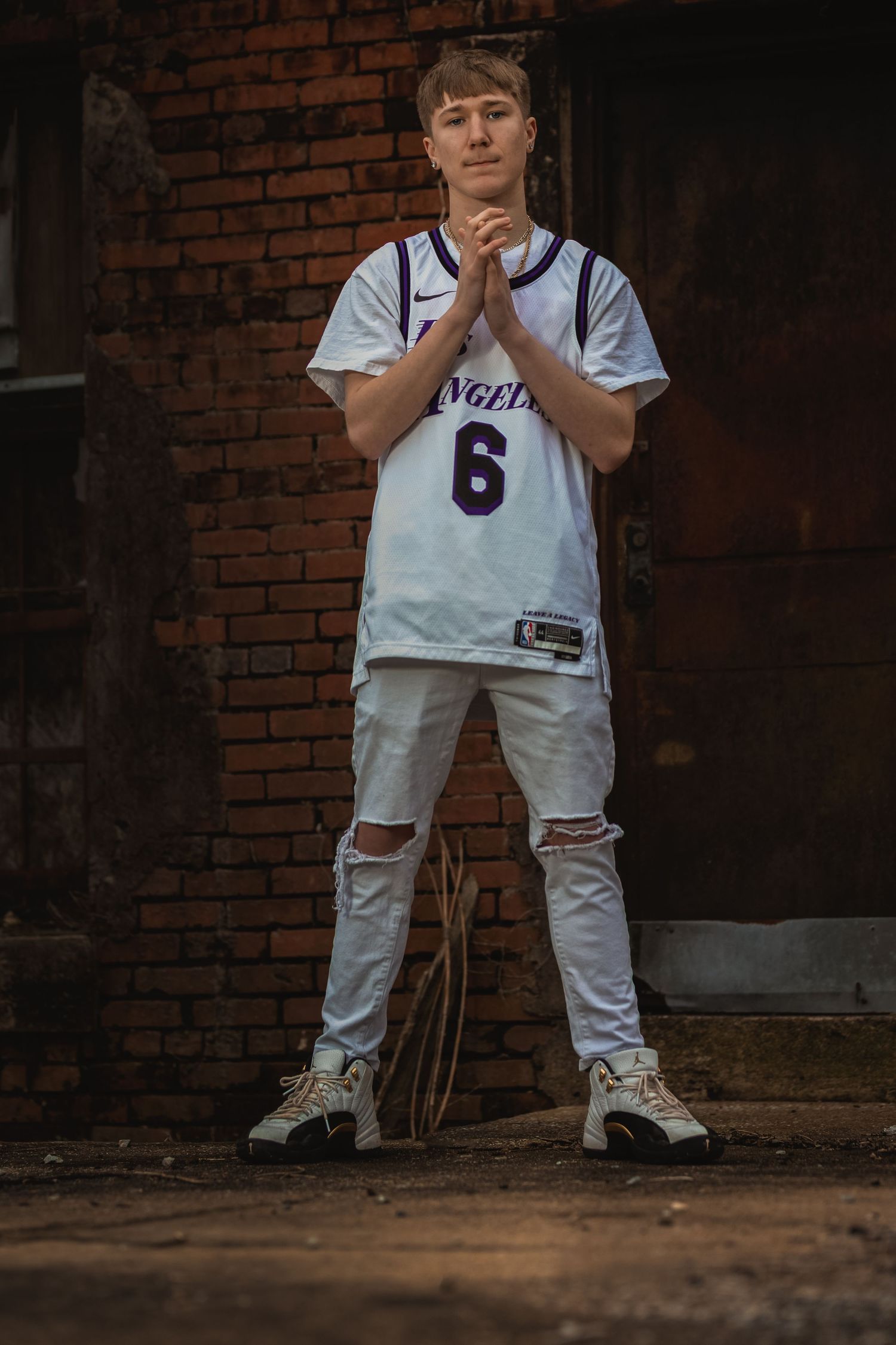 Urban-style senior portrait captured in front of a rustic brick building in Lincoln, Alabama