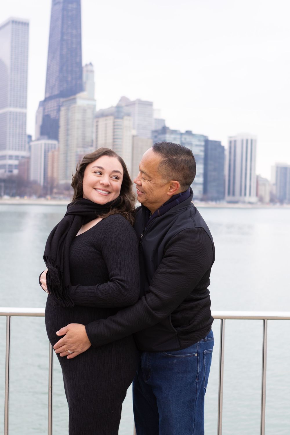 A couple shares romantic moments by the Chicago waterfront with the city skyline in the background.