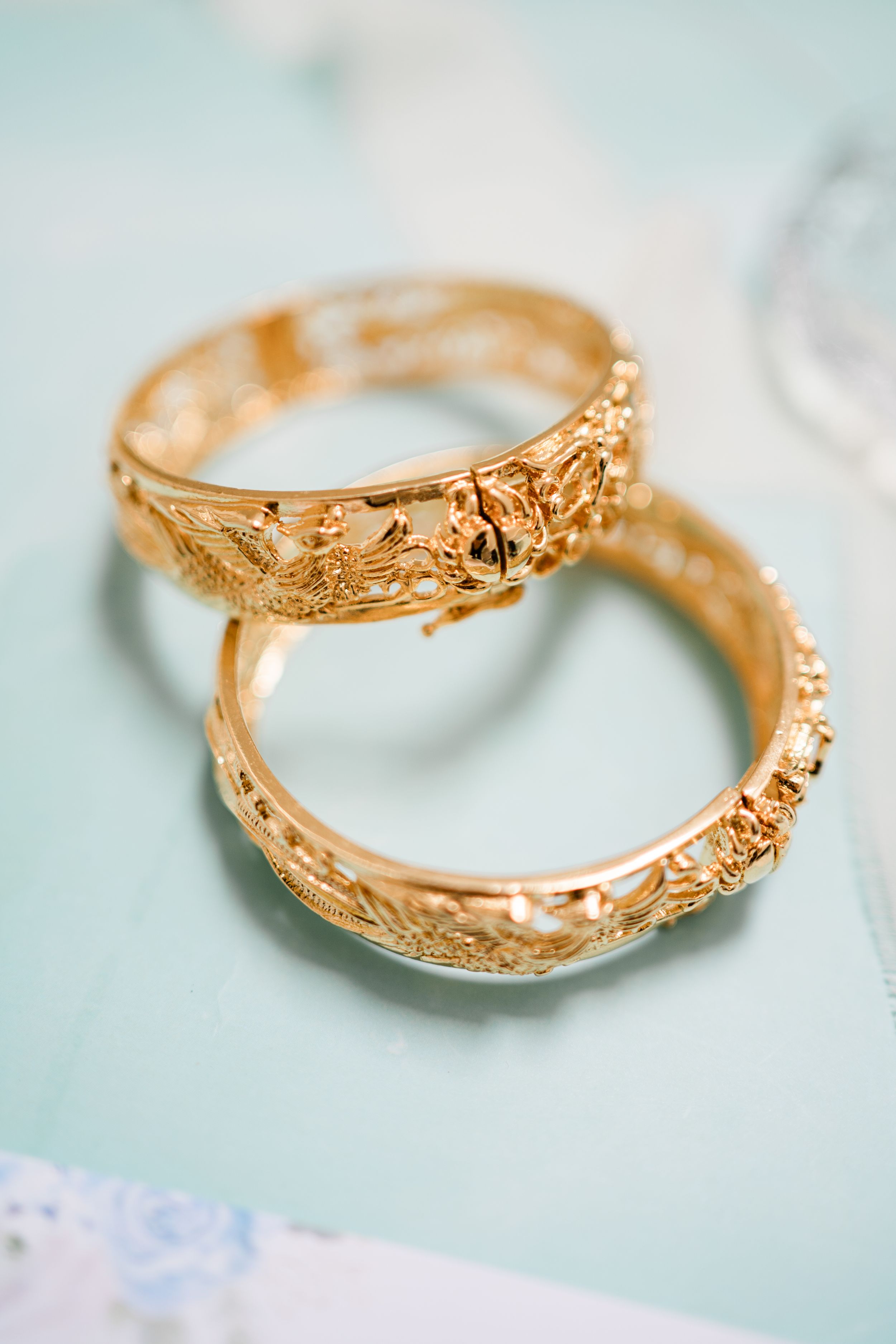 classic and timeless close-up of two golden wedding rings with engraved patterns, symbolising love and tradition during bridal prep.