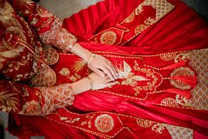 Close-up of intricate embroidery and detail on the bride’s traditional Chinese wedding dress at her timeless Wollaton Hall wedding venue.
