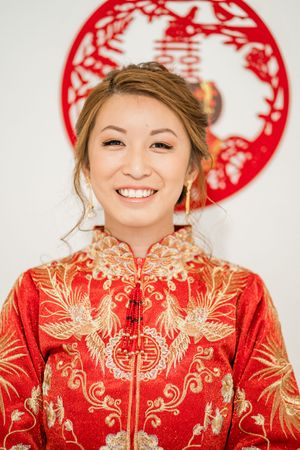 Portrait of the bride smiling in her traditional Chinese wedding dress, beautifully blending culture and elegance at Wollaton Hall.
