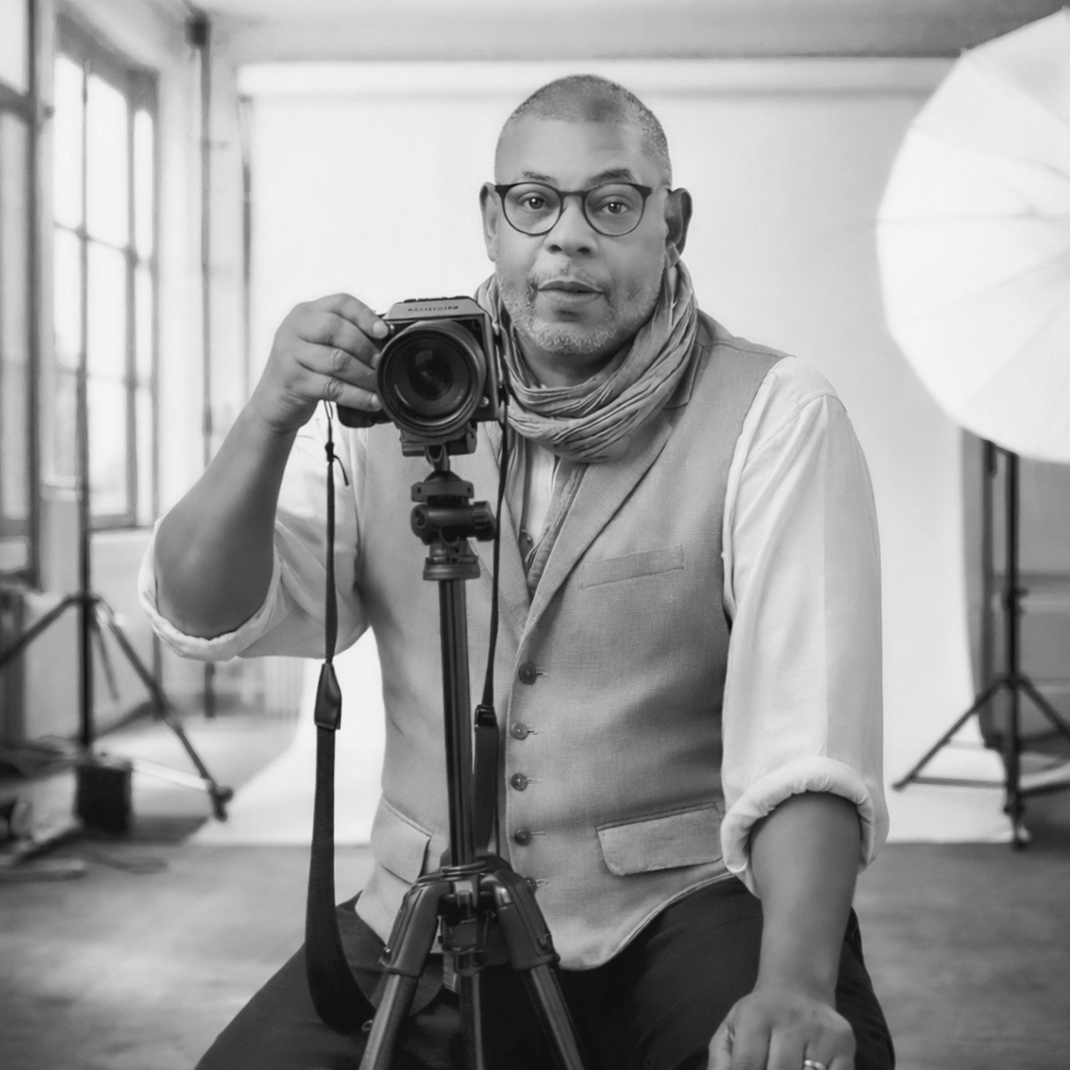 Black and white photo series showing a photographer working with camera equipment in a studio setting.