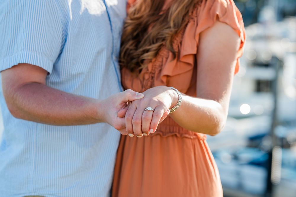 Close-up shots of a couple holding each other near a waterfront marina. Harbor Point Boardwalk in Stamford, CT