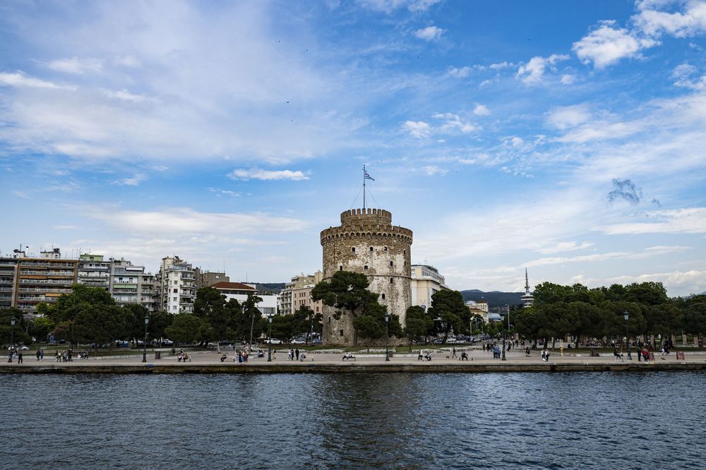 Panoramic view of Lake Merritt in Oakland California with city buildings and blue sky reflecting on calm waters.