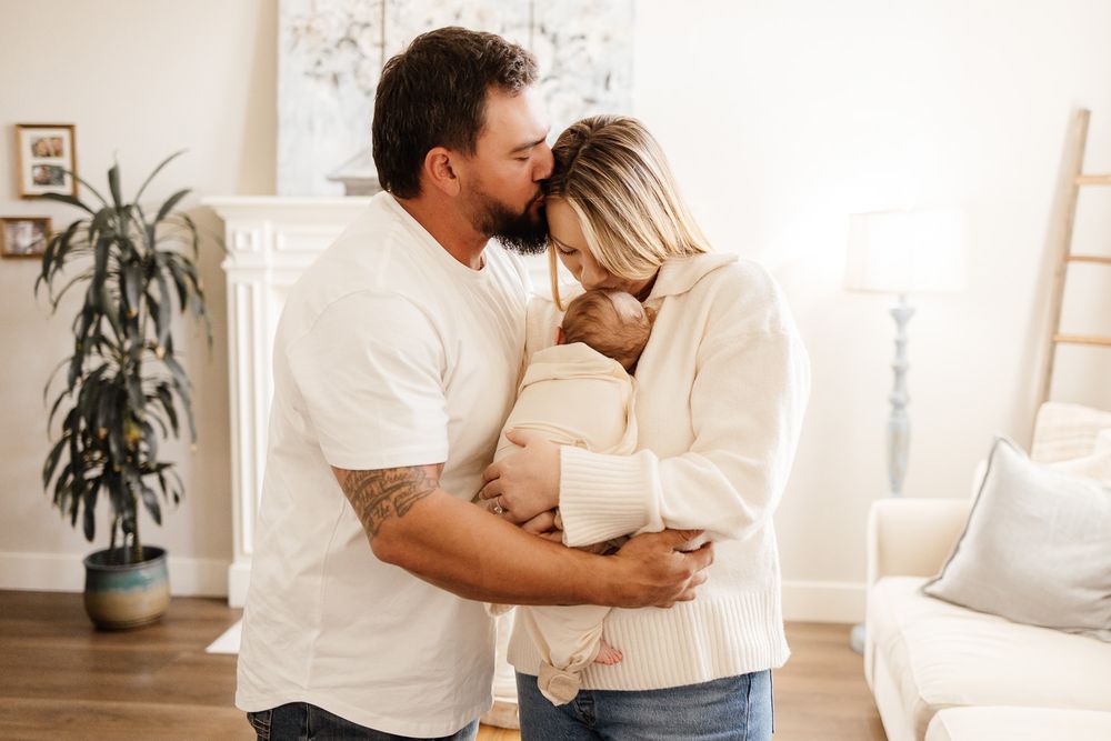 parents snuggle their baby in their bright Sunnyvale living room during their at home photography session