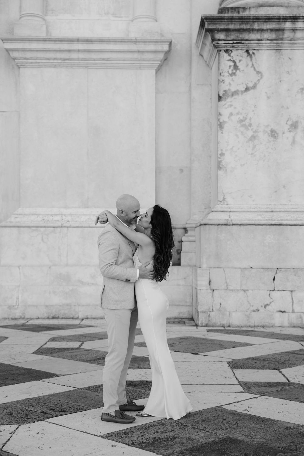 A series of dance movements captured in black and white showing a couple's romantic interaction near white columns.