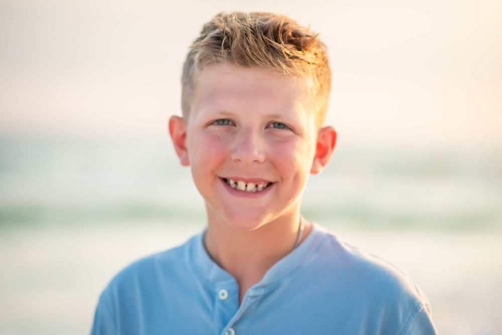 Children enjoying a sunny day at the beach with soft golden light and coastal scenery.