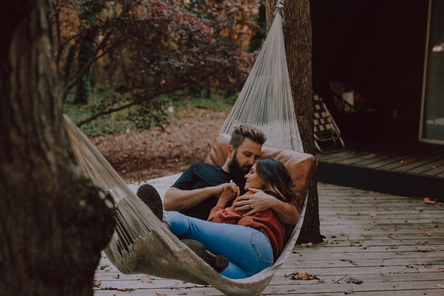 couple lay in a hammock on the patio of their A-frame B&B, 1000 islands, Ontario.