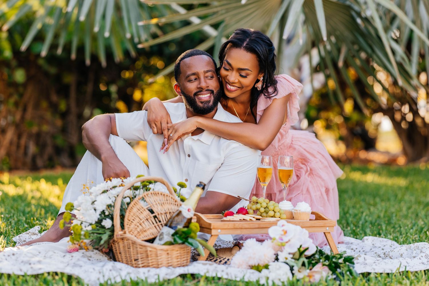 Couple celebrating joyfully against a sparkling gold sequin backdrop.