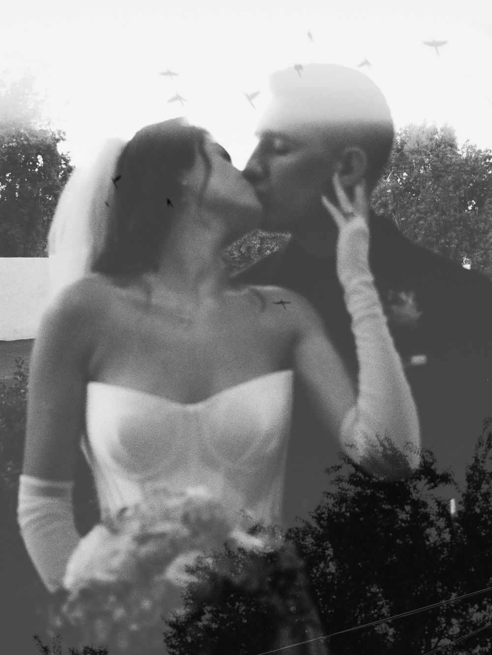 Black and white double exposure photo of bride and groom kissing on their wedding day.