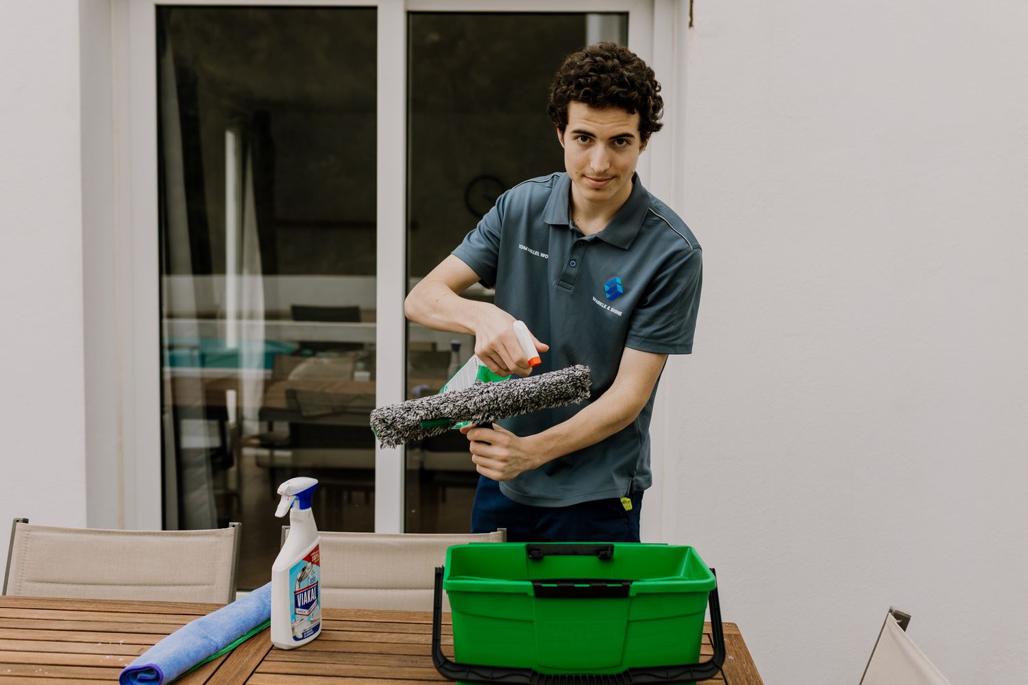 Image of Tom spaying cleaning material on his window cleaning squeegee.
