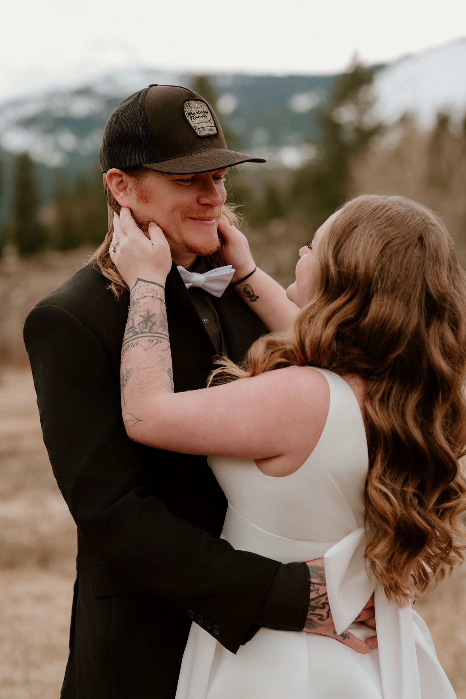 A couple shares intimate romantic moments in a series of outdoor portraits against a mountain backdrop.