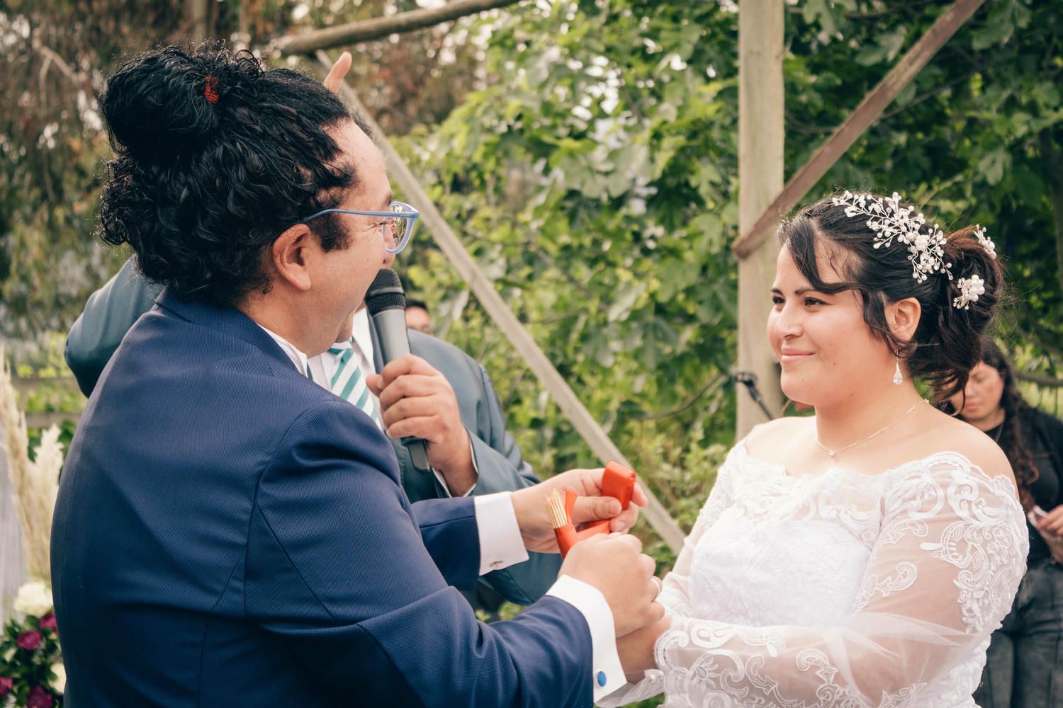Ceremonia romántica de matrimonio en jardín con decoraciones florales y arco de madera.