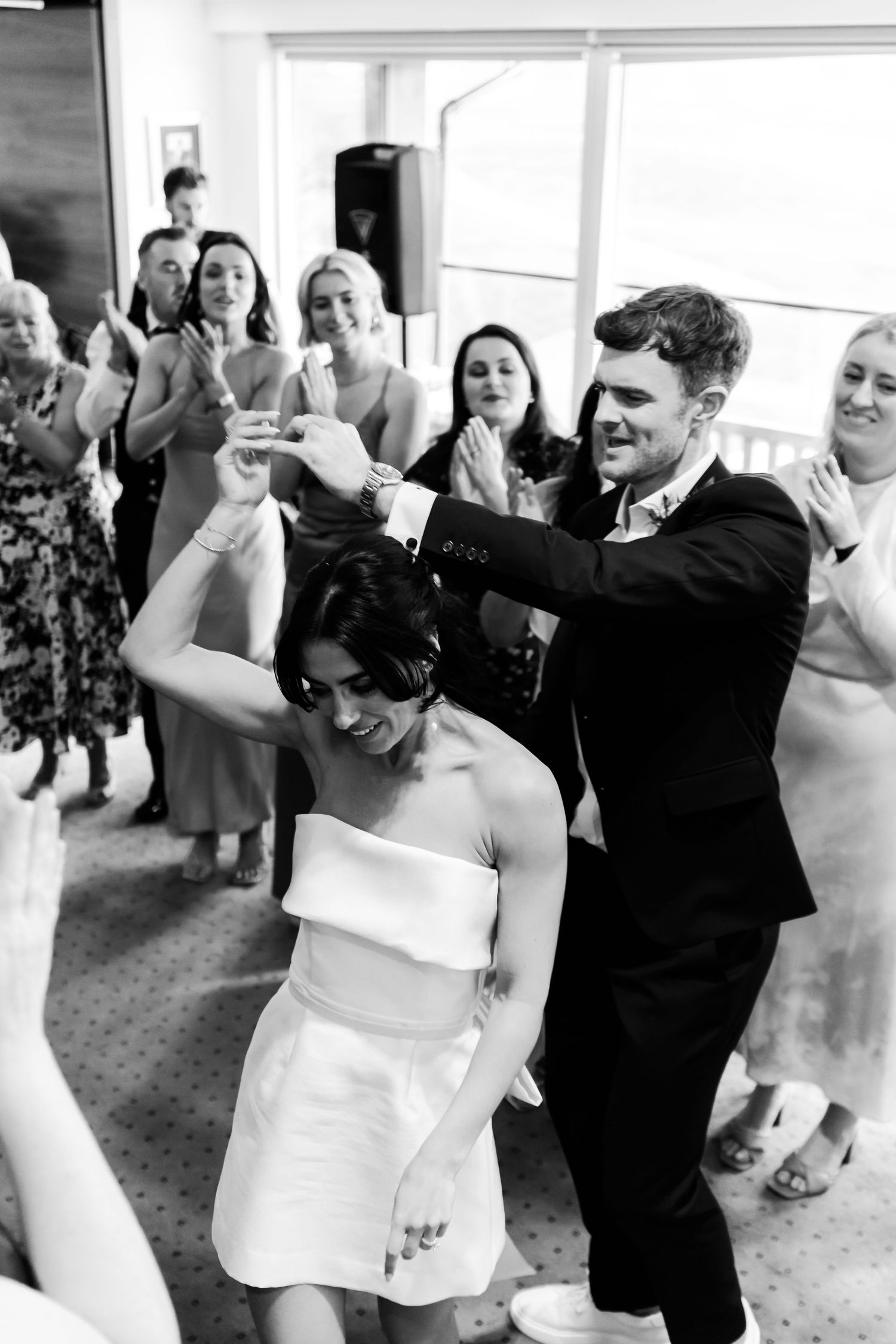 A series of black and white photos showing a couple dancing together at a wedding reception.