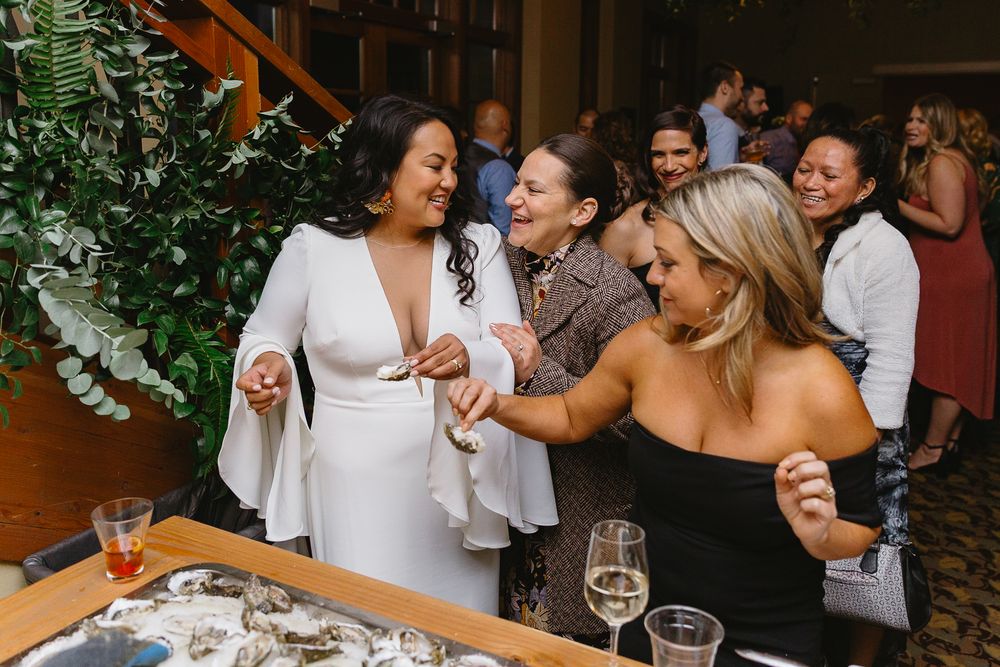 People mingling and socializing at a festive indoor gathering with wine glasses.