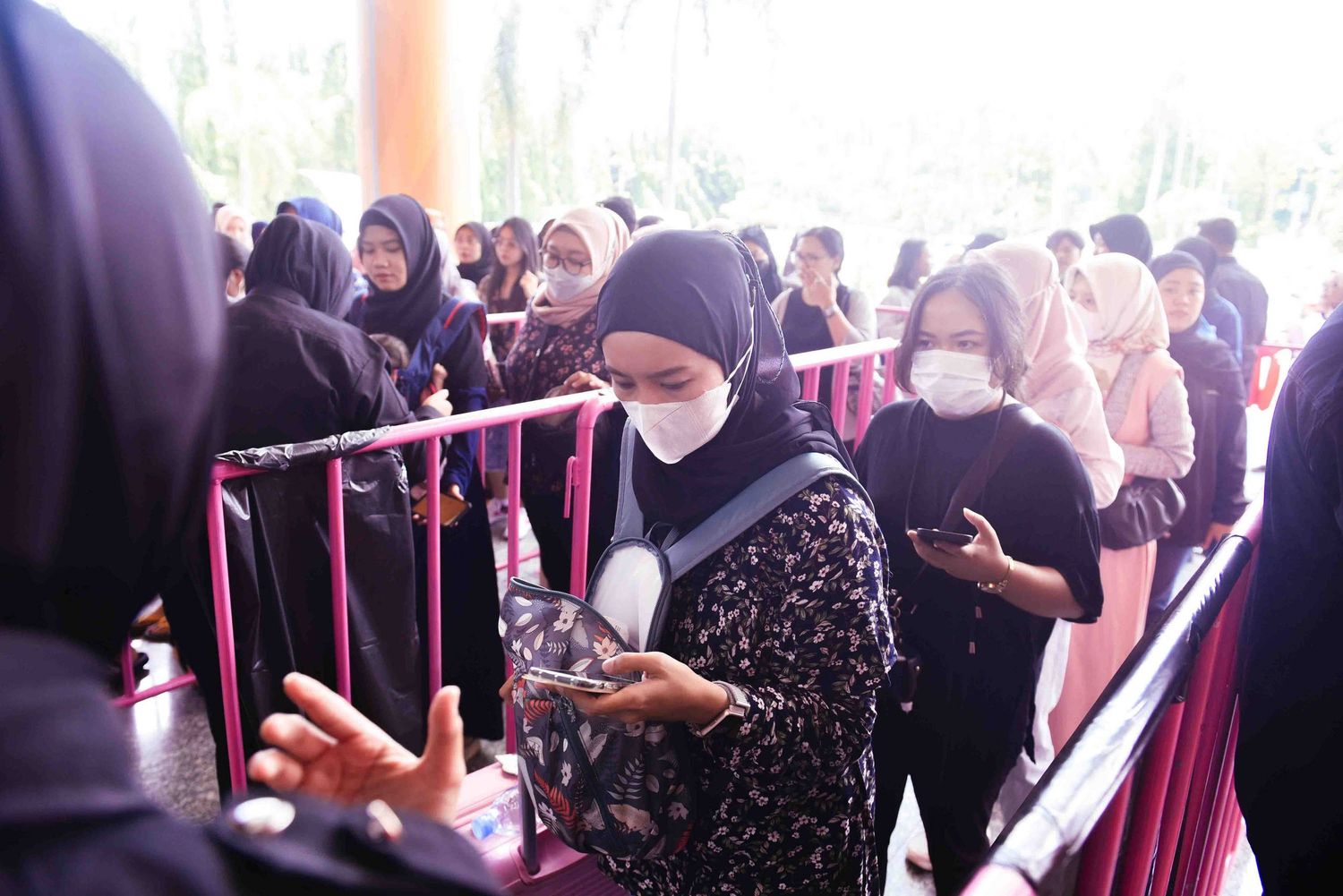 A crowded queue of people waiting in line at an indoor venue.