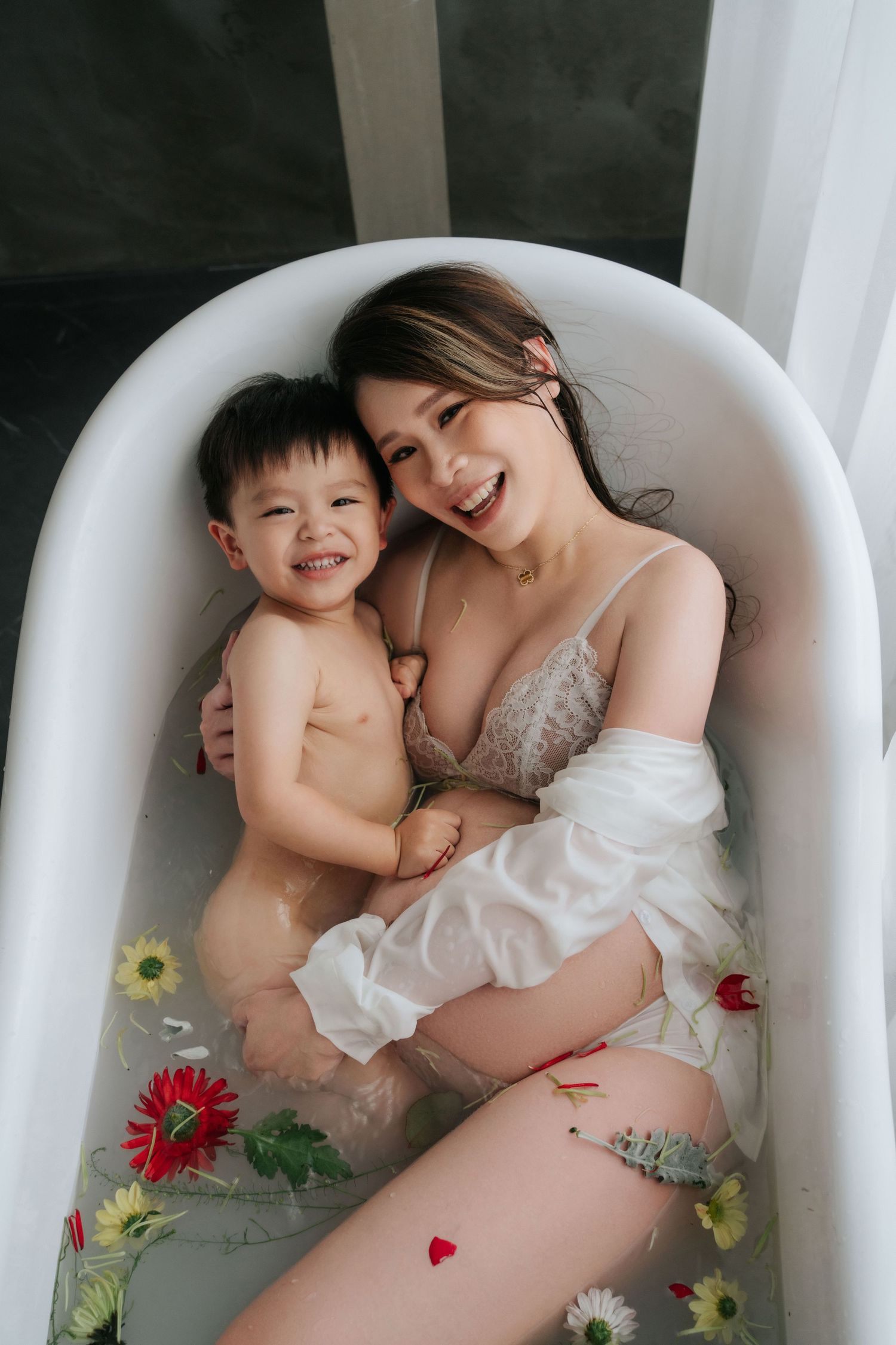 A joyful bath time moment decorated with floating flowers in a white bathtub.白色浴缸裡漂浮著鮮花，營造出歡樂的沐浴時光。