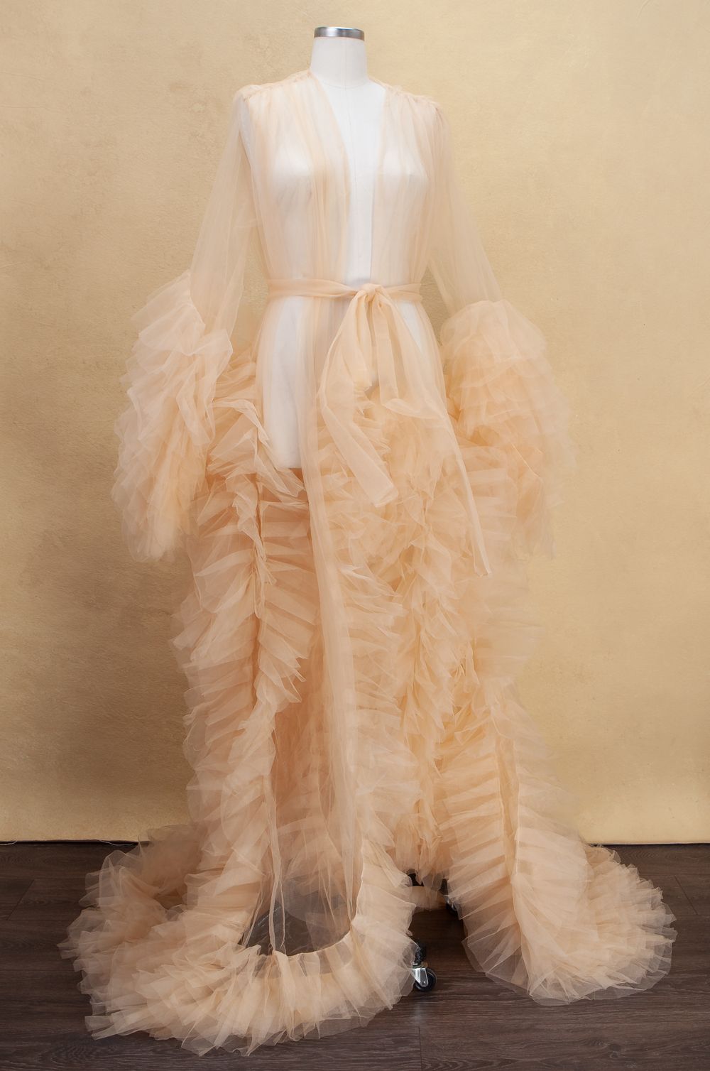 Elegant peach-colored tulle maternity gown with flowing ruffles and sheer sleeves photographed in sequence.