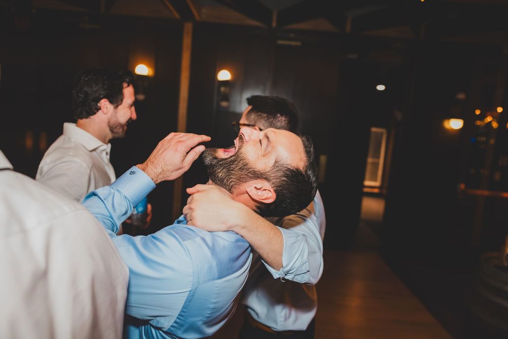 A couple shares a laught and dance together on a dimly lit dance floor at an evening celebration.