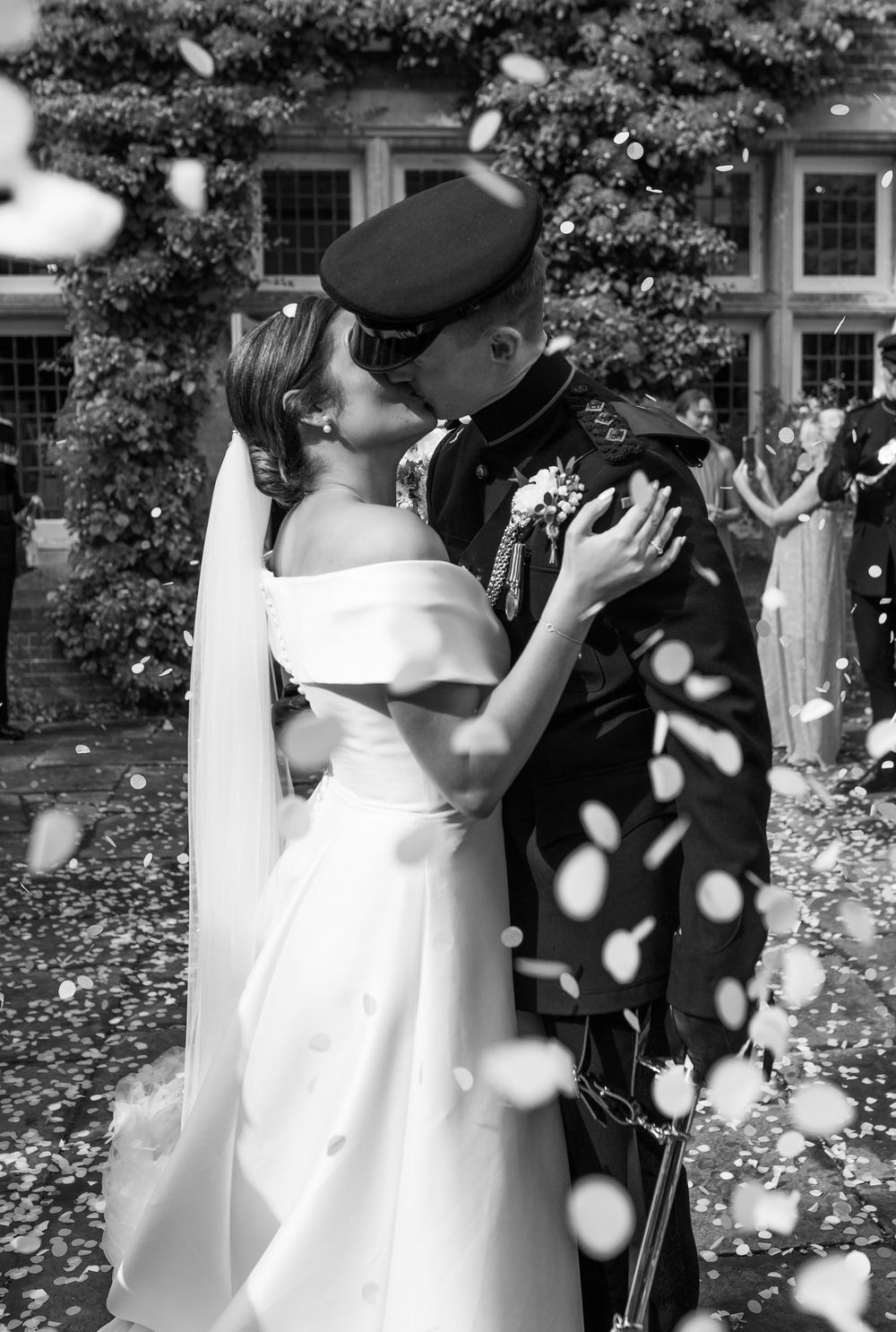 Black and white wedding photo sequence showing a couple embracing while rose petals fall around them.