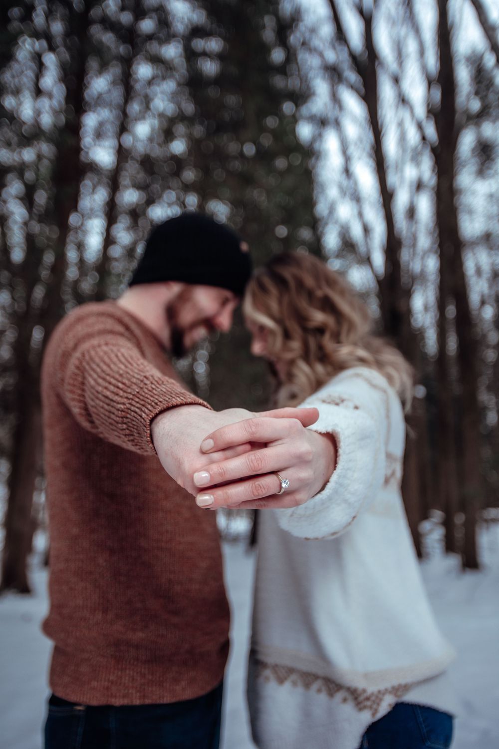 Winter engagement photoshoot sequence showing couple dancing in snowy forest.