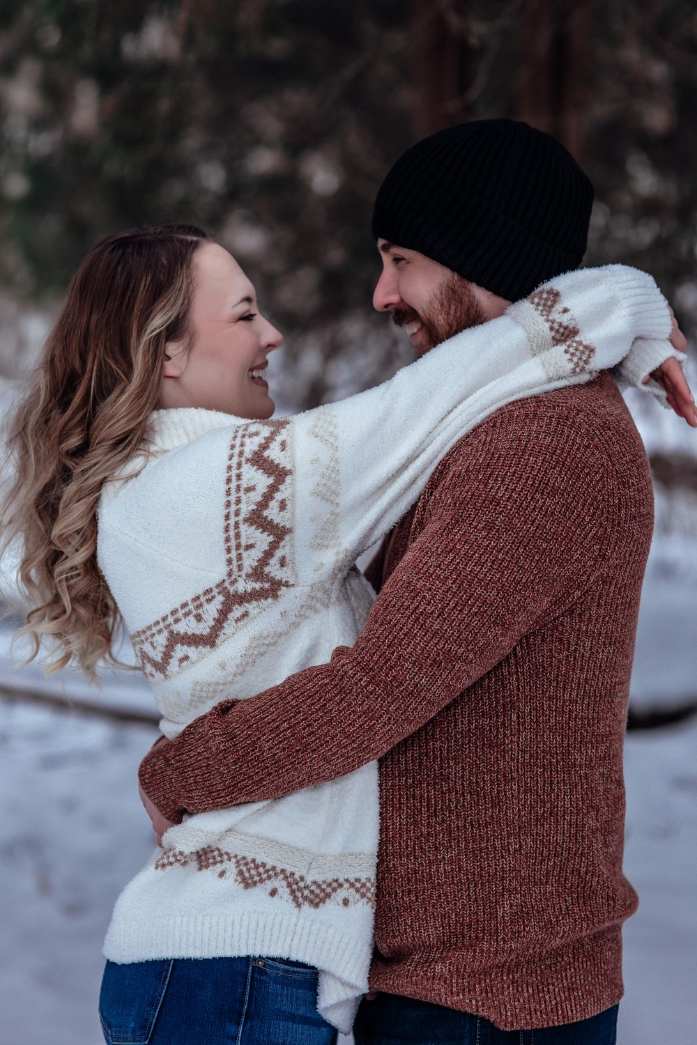 Romantic winter couple photos featuring coordinated knit sweaters in brown and white.