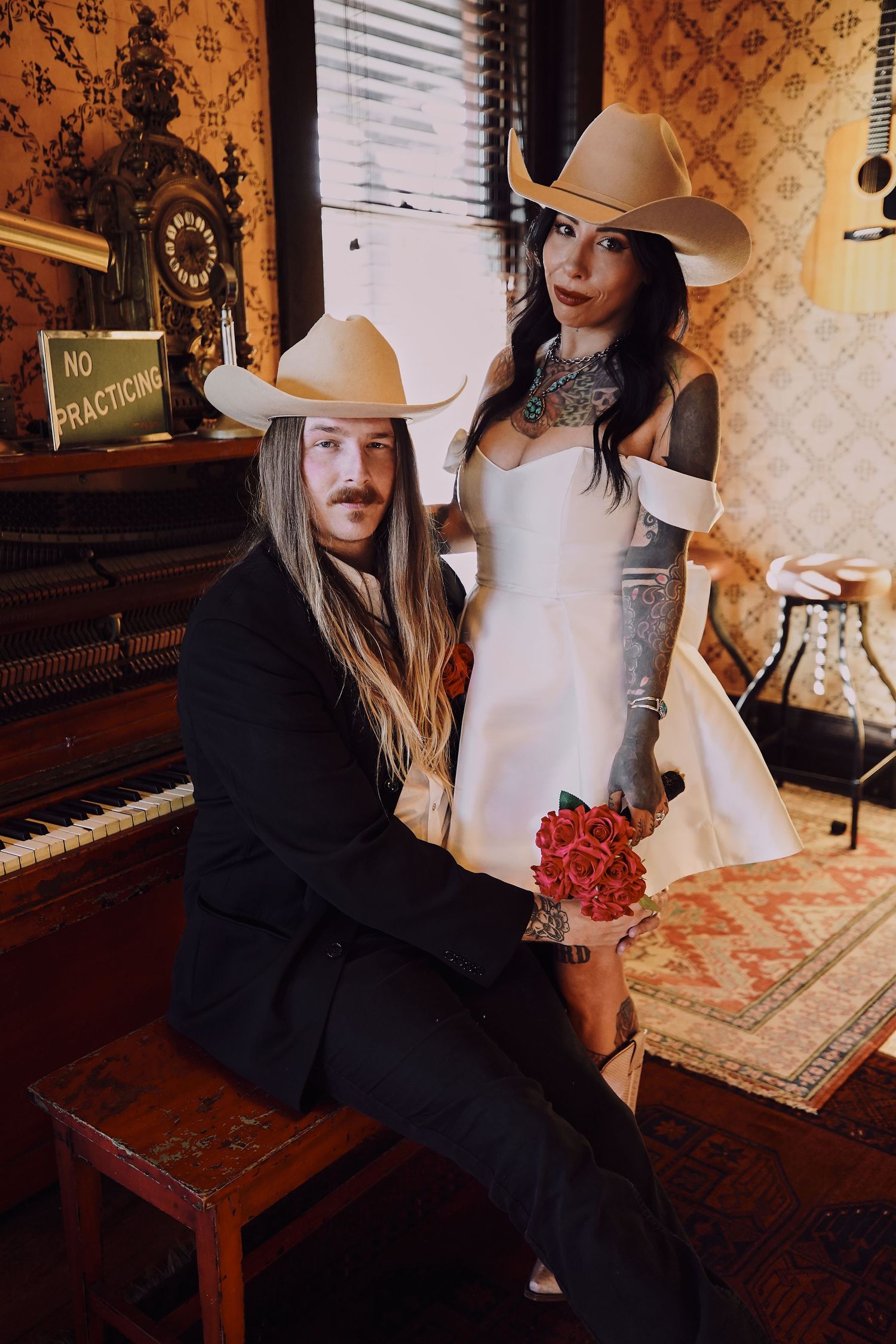 Vintage-style photoshoot in room with piano and patterned wallpaper.