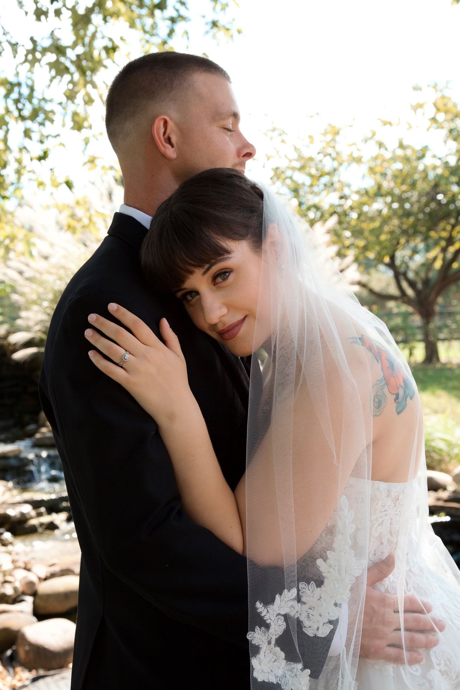 A romantic wedding moment captured outdoors with delicate lace veil details.