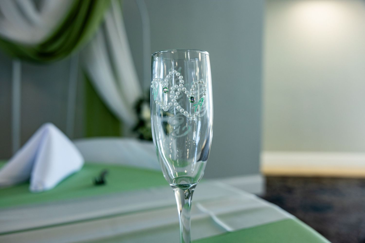 Elegant place settings with wineglasses and light green napkins arranged on an upscale dining table.