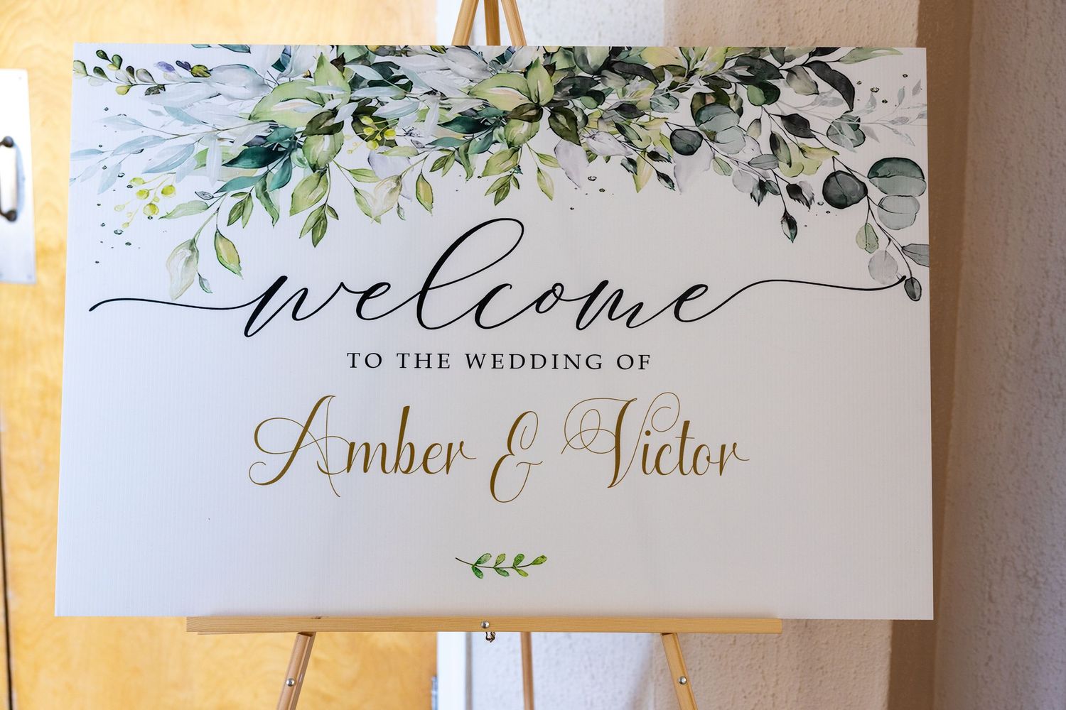 Elegant wedding welcome signs with floral watercolor designs and calligraphy displayed against a white wall.