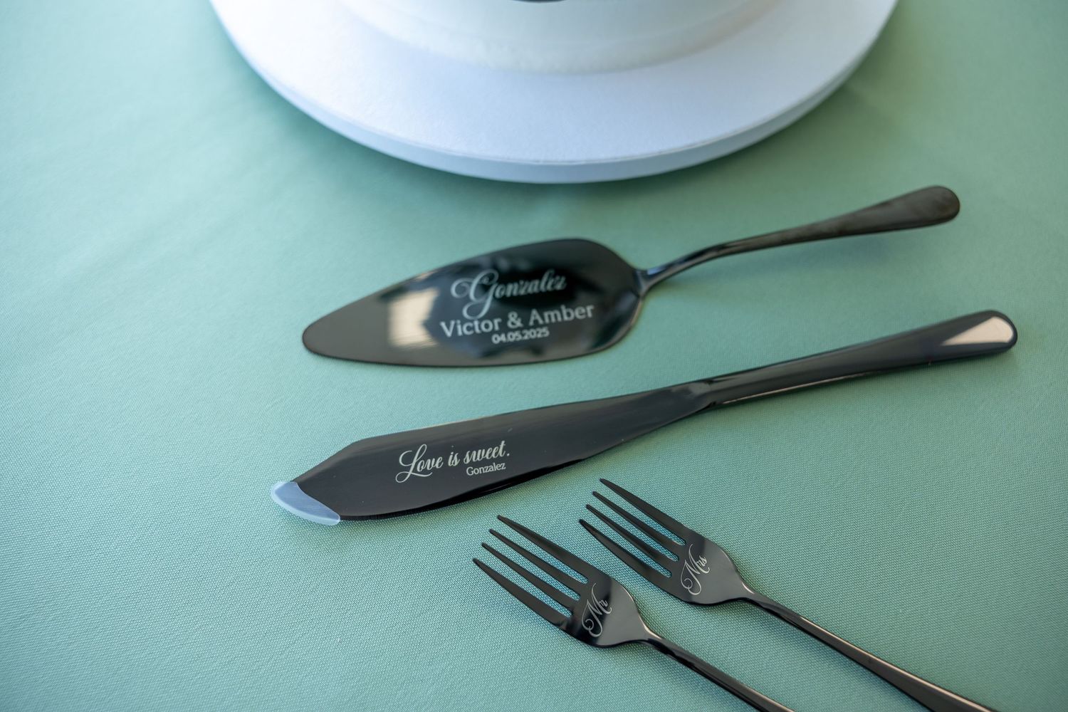 Vintage silverware and utensils arranged on a mint green table surface.