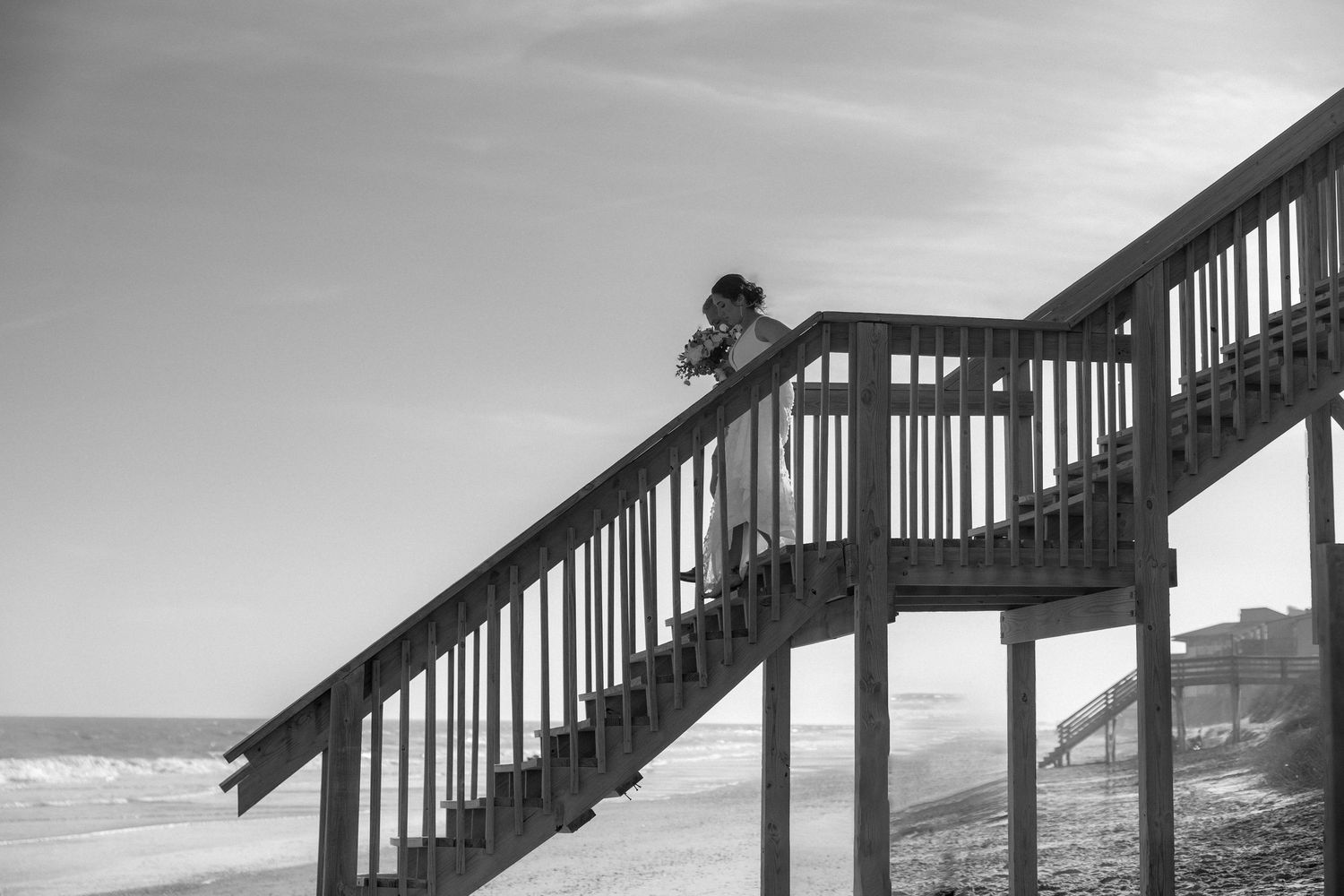 Multiple black and white photos showing a wooden staircase leading to a beach along the coastline.
