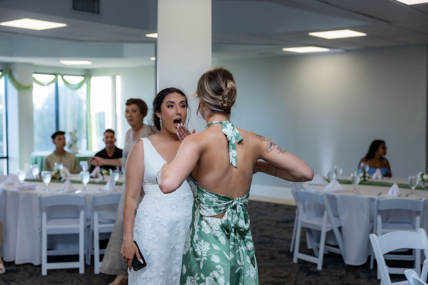 Wedding reception venue with white chairs and event decor in a bright indoor space.