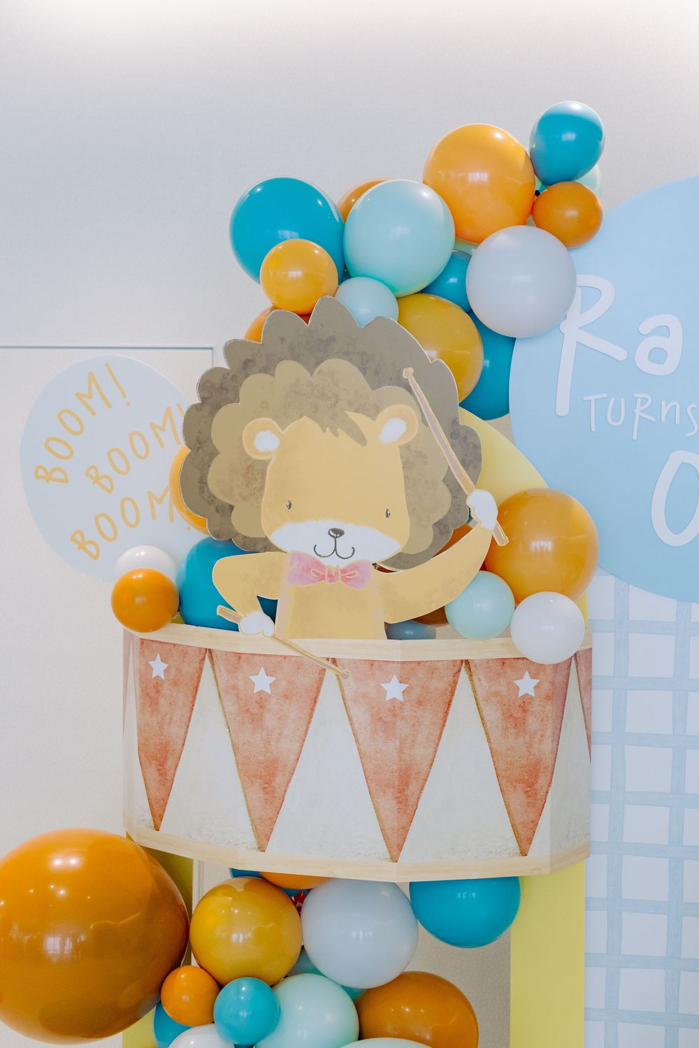 Festive party decorations featuring a lion theme with blue and orange balloons against a light backdrop.