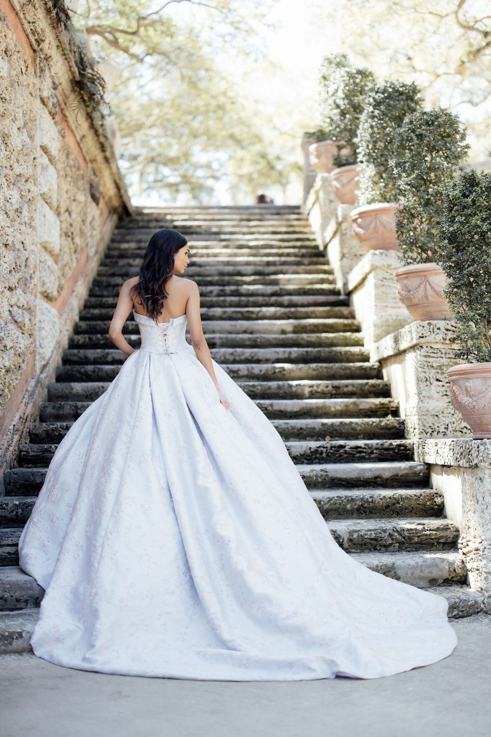 A stunning white ball gown wedding dress photographed in a series across stone steps and archways.