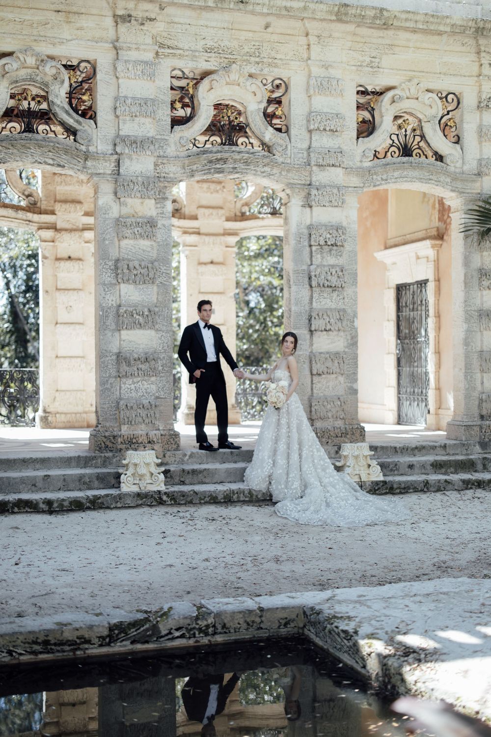 Stone courtyard with ornate carved details and columns casting dramatic shadows.