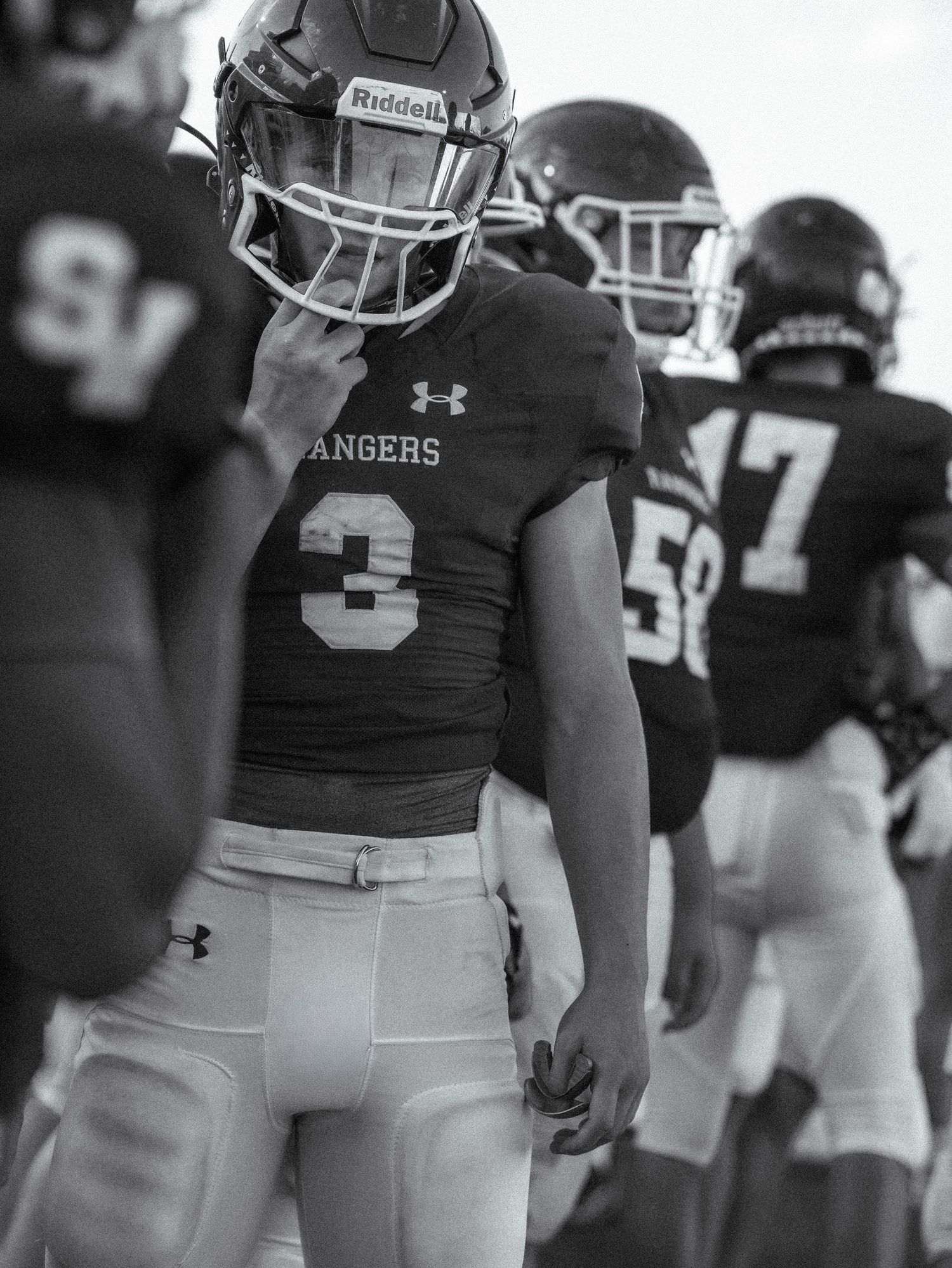 Football players in Under Armour uniforms lined up during a game or practice.