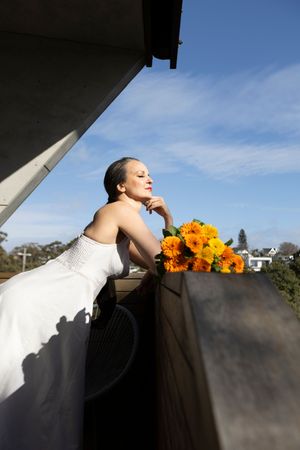 A dramatic composition with sunflowers against a white surface and blue sky as a backdrop.