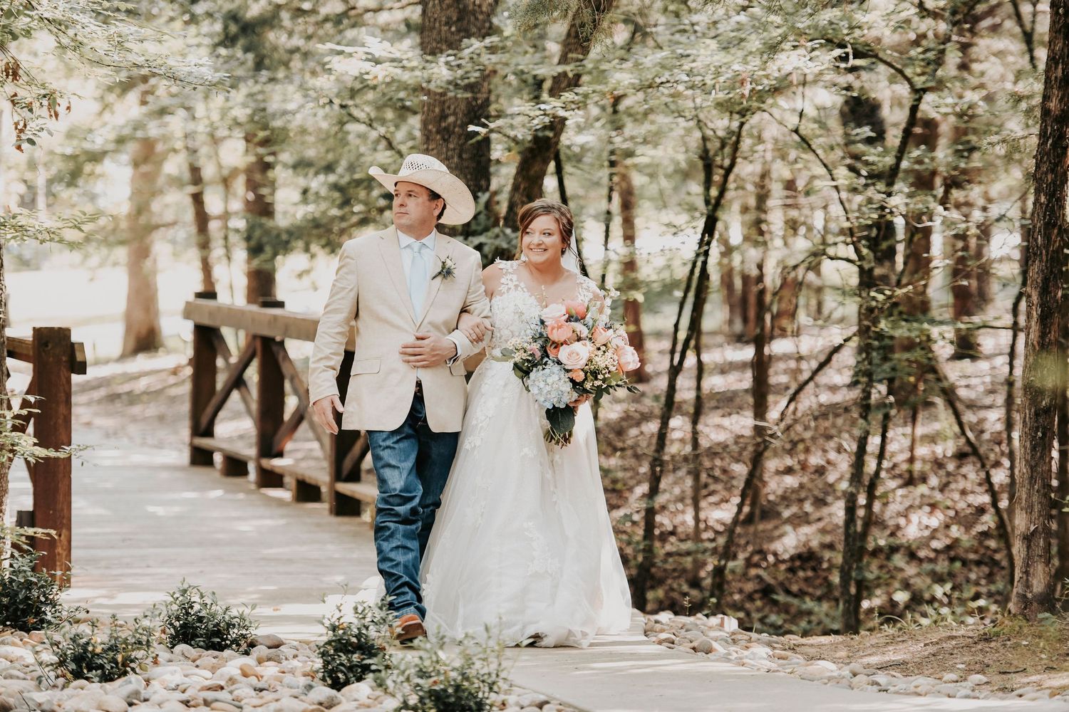Bride over the rustic bridge at Whispering Oaks wedding venue