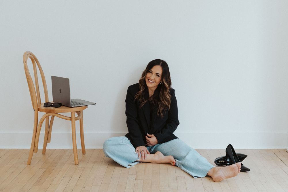 Casual branding photo with black top and light denim in minimalist setting.