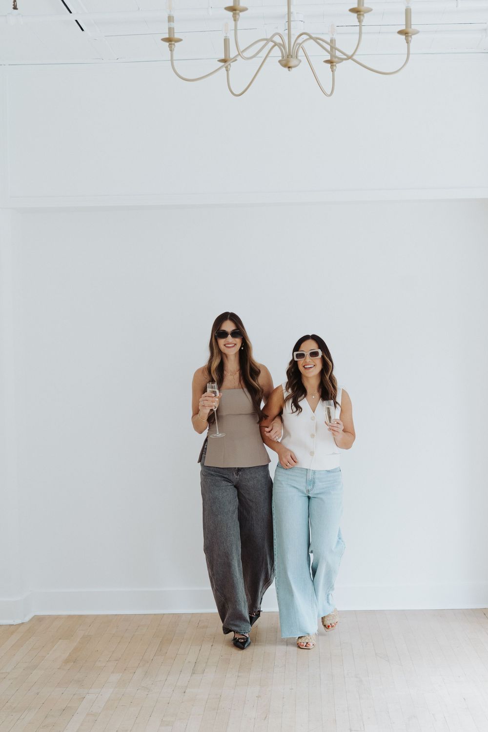 Branding photoshoot of two founders in coordinated casual outfits against white background.